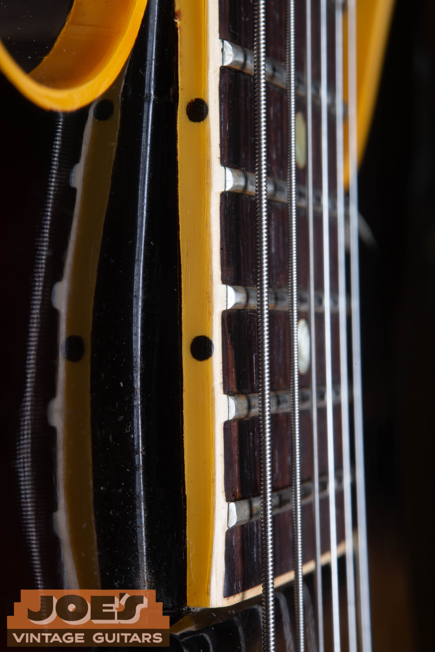 Fret nibs on the binding edge of a 1959 Gibson ES-330 fretboard — the binding extends above the fret ends creating a smooth edge