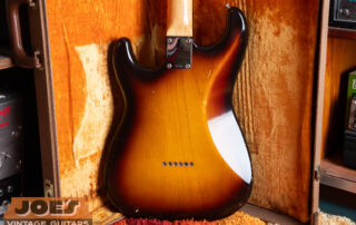 Rear view of a vintage Fender Stratocaster hardtail body showing the solid wood construction with six chrome string-through-body ferrules and the absence of a tremolo spring cavity or plastic backplate.