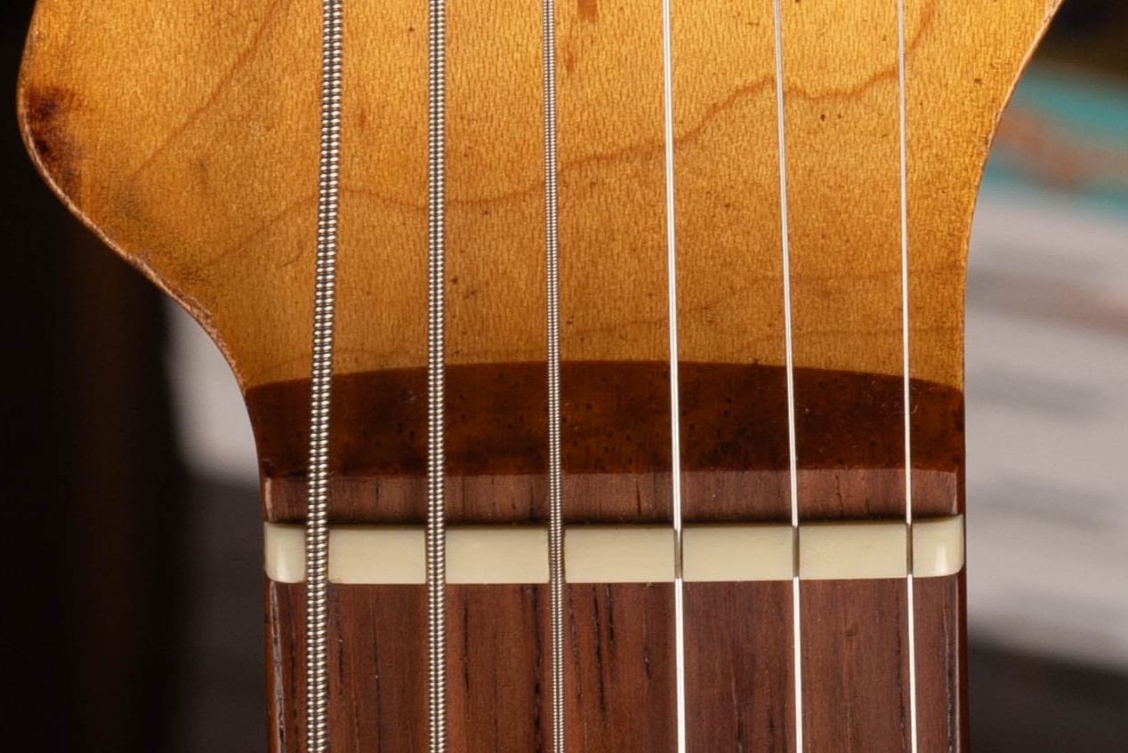 1962 Fender Stratocaster slab rosewood fingerboard nut area — approximately 4.8mm thick flat-bottom board showing deep rosewood depth at headstock end