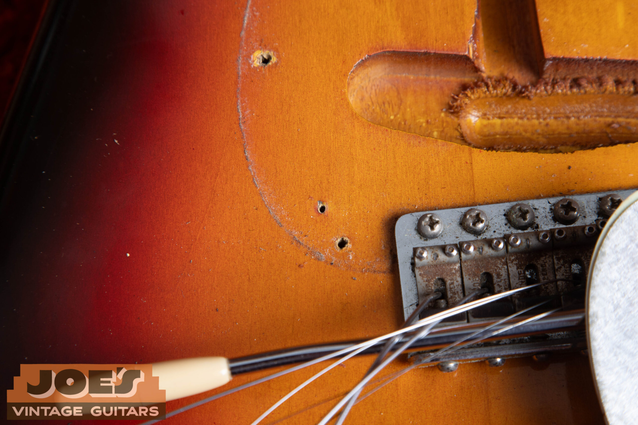 1962 Fender Stratocaster body face nail hole under pickguard area — finishing suspension point hidden beneath the pickguard on the body face