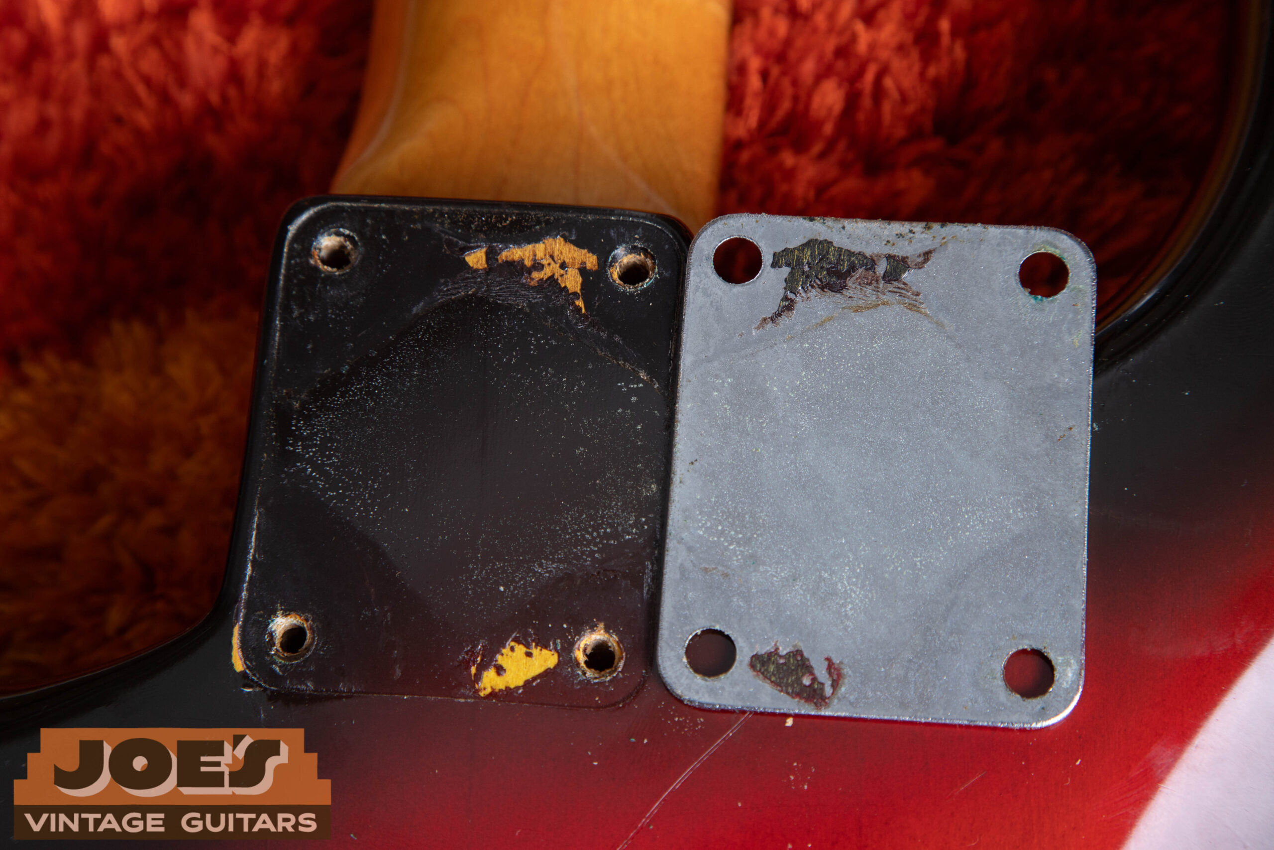 1962 Fender Stratocaster neck plate removed showing puzzle piece finish pattern — lacquer chips and wear along plate edge match the finish underneath confirming original unswapped plate