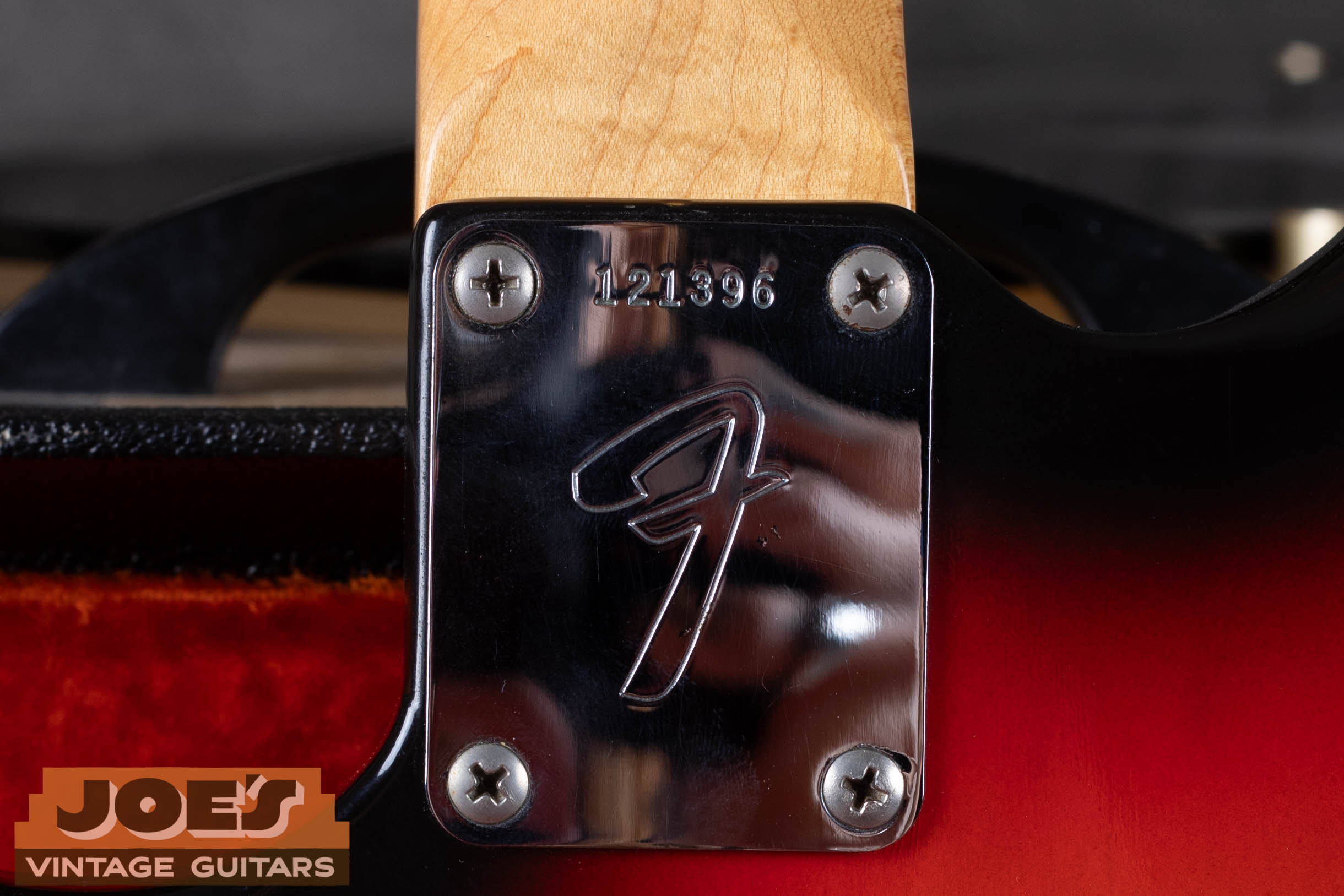 Fender Jazzmaster CBS-era F-logo neck plate with serial number — large stylized F on chrome neck plate indicating post-1965 CBS production