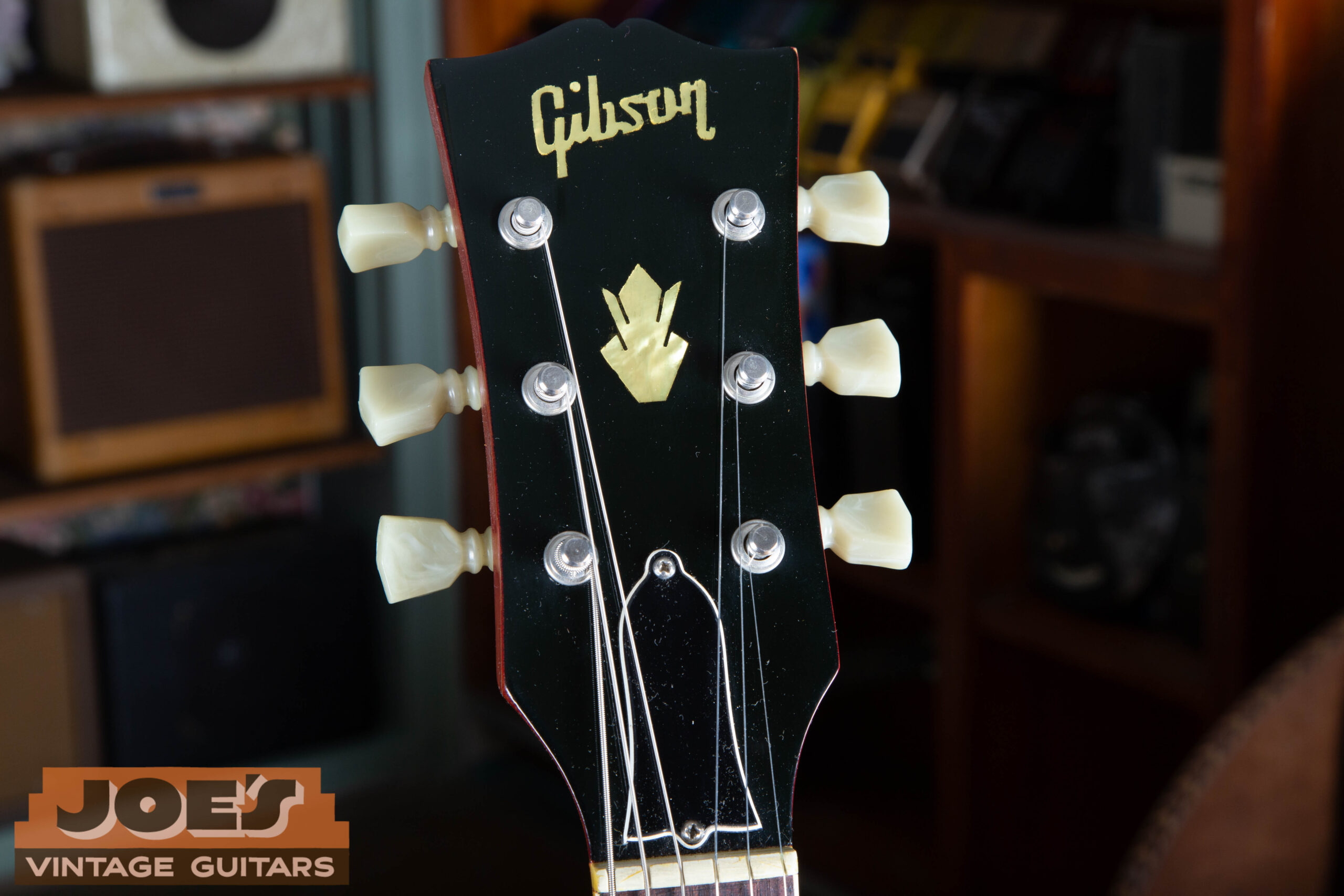1966 Gibson ES-335 headstock showing silk-screened Gibson logo, crown inlay, bell-shaped ADJUSTABLE truss rod cover, and Kluson double-line tuners