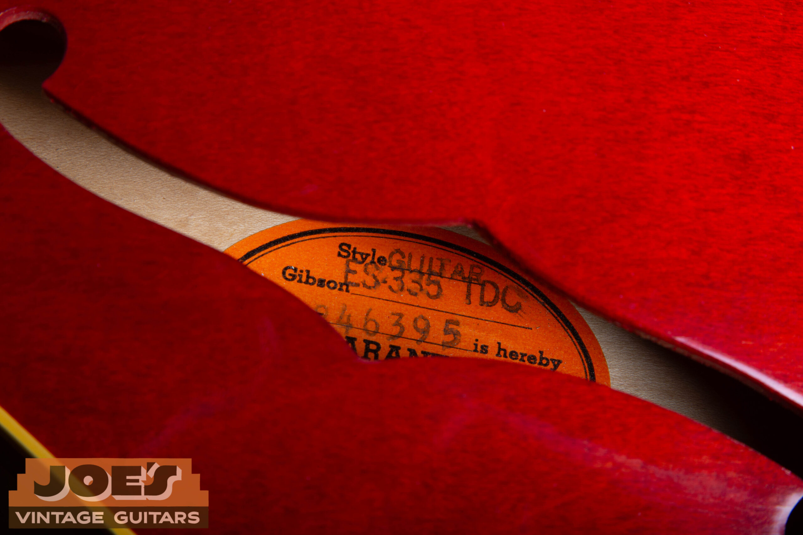 1966 Gibson ES-335 orange oval label visible through f-hole — STYLE ES-335 TDC Kalamazoo Michigan serial number confirming 1966 Kalamazoo production