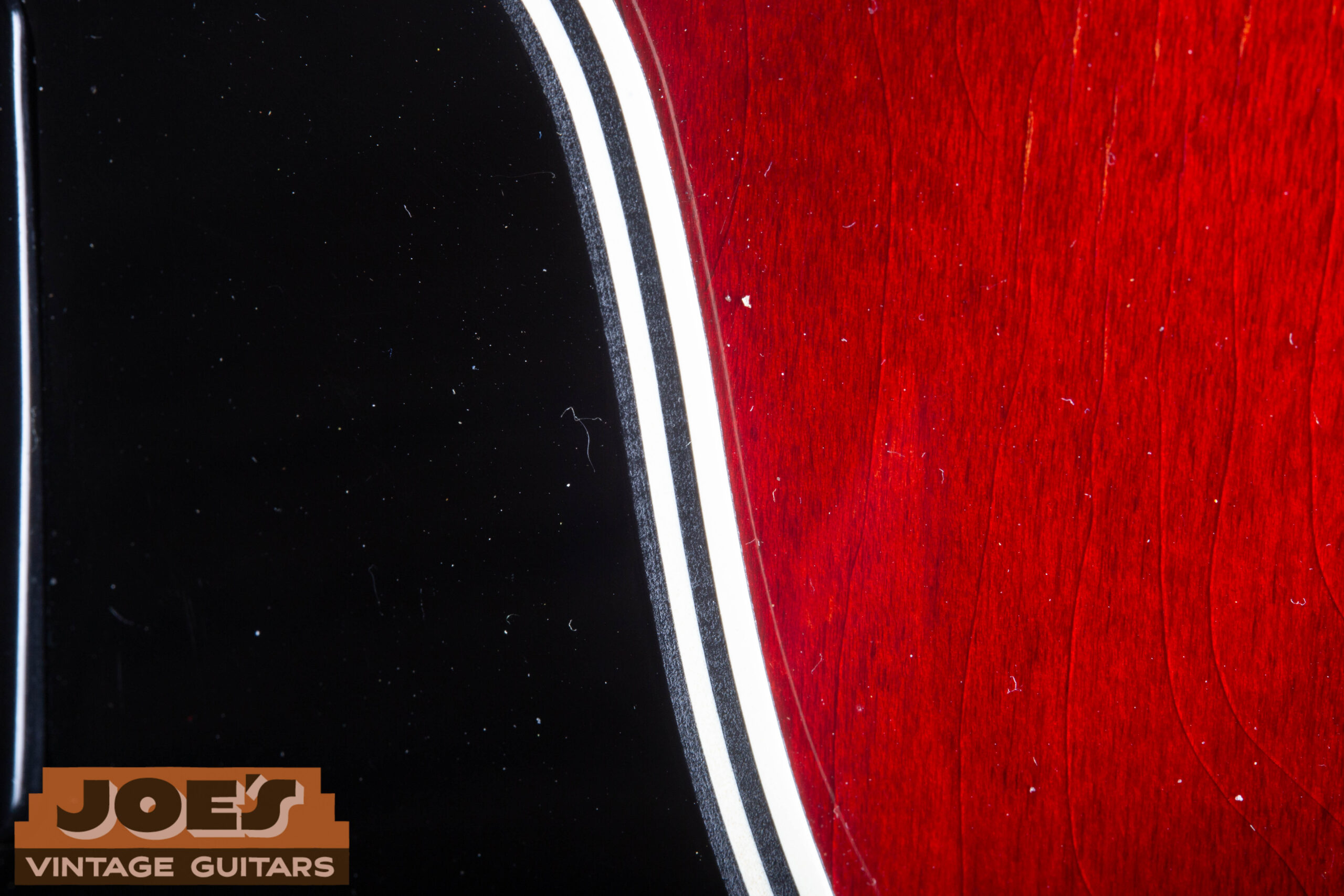 1966 Gibson ES-335 multi-layer pickguard edge close-up showing laminated layers — authentic period construction with visible layer sandwich at cut edge