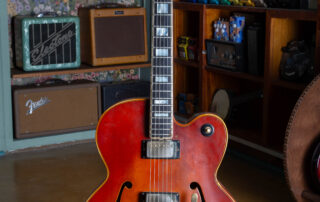 1969 Gibson L-5 CES hollow body electric guitar in a sunburst finish, featuring a Florentine cutaway, gold hardware, and a Bigsby vibrato tailpiece. The guitar is shown without a pickguard, highlighting the wood grain and dual humbucking pickups.