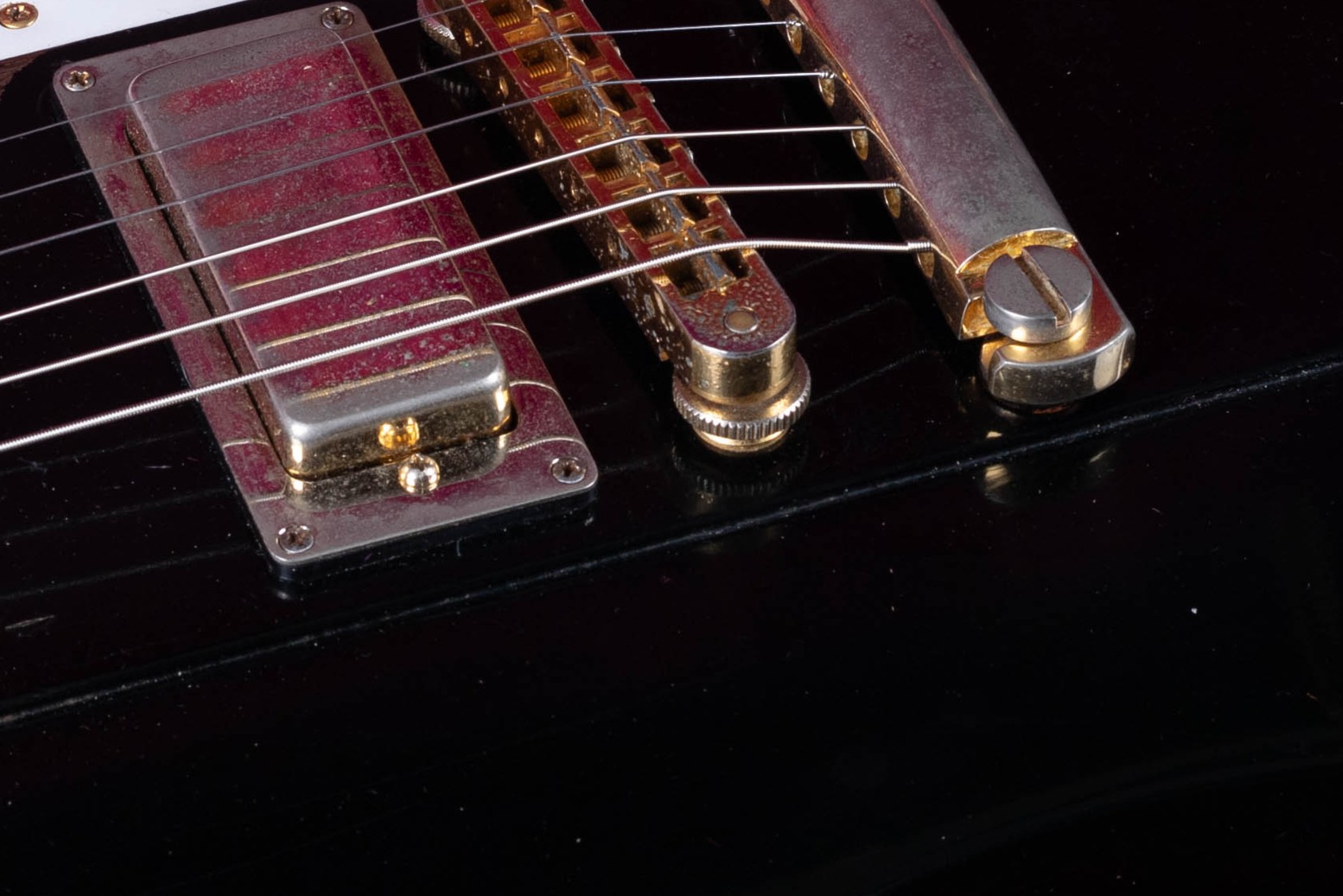 Nashville Tune-O-Matic bridge on a Gibson — the larger replacement for the ABR-1 introduced in 1974 and standard from 1975, identifiable by the threaded metal inserts the post studs screw into