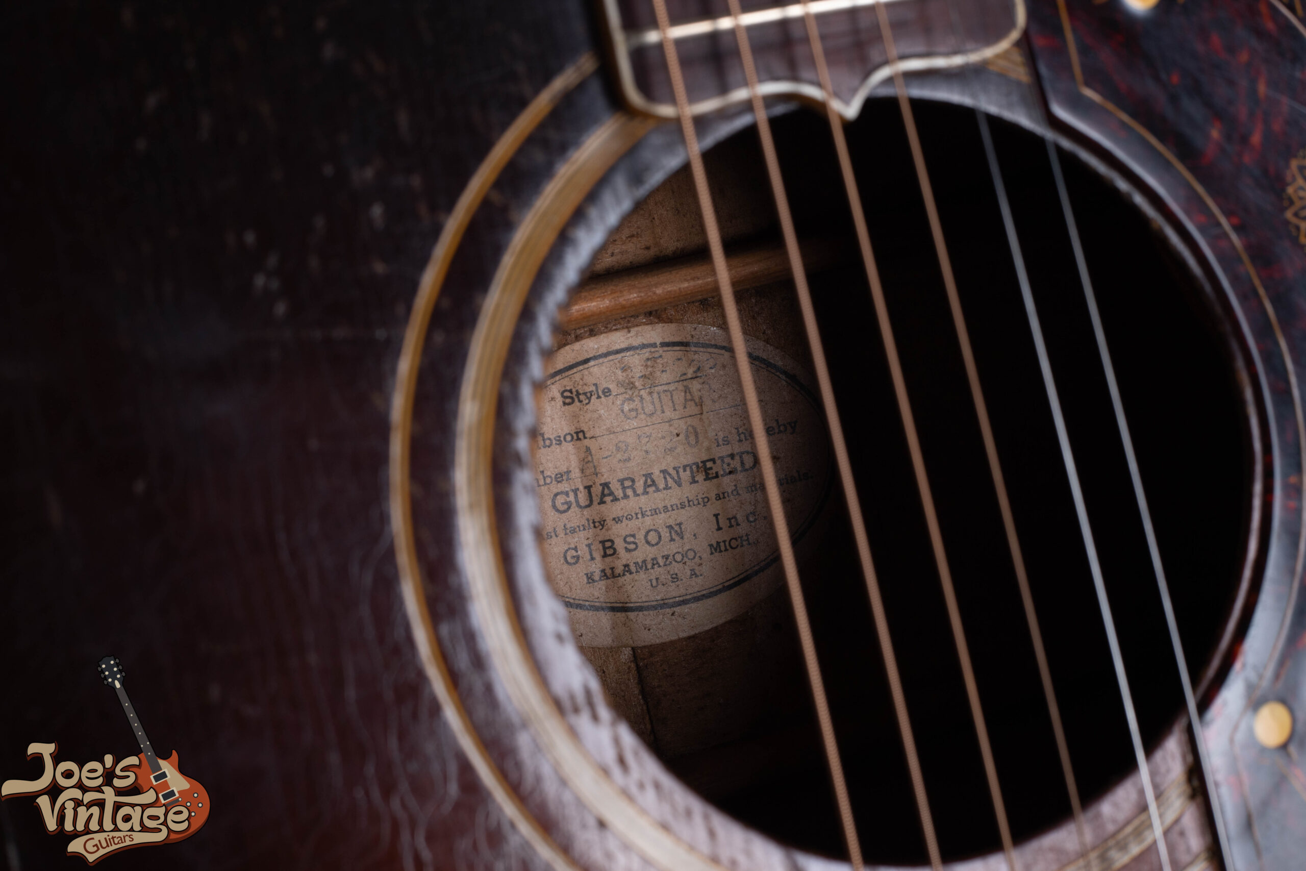 Vintage Gibson white oval interior label showing handwritten serial number from the early Kalamazoo era
