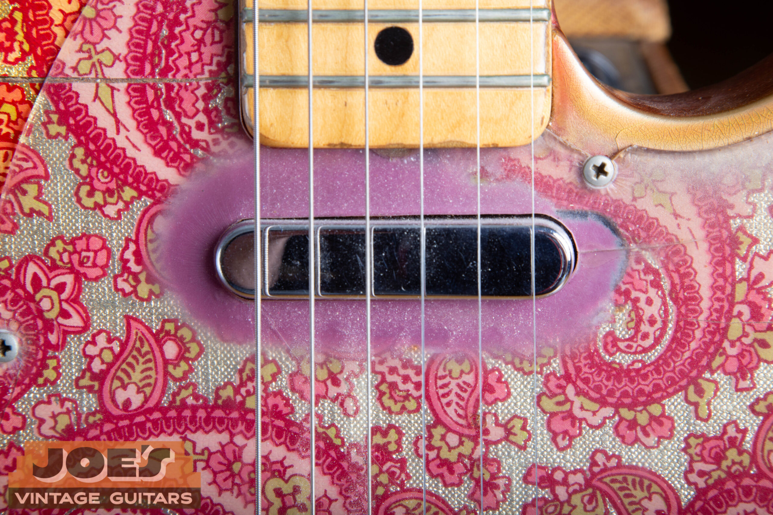 Pink burst paint sprayed around the neck pickup cavity on the back of the pickguard on a 1968 Fender Paisley Telecaster