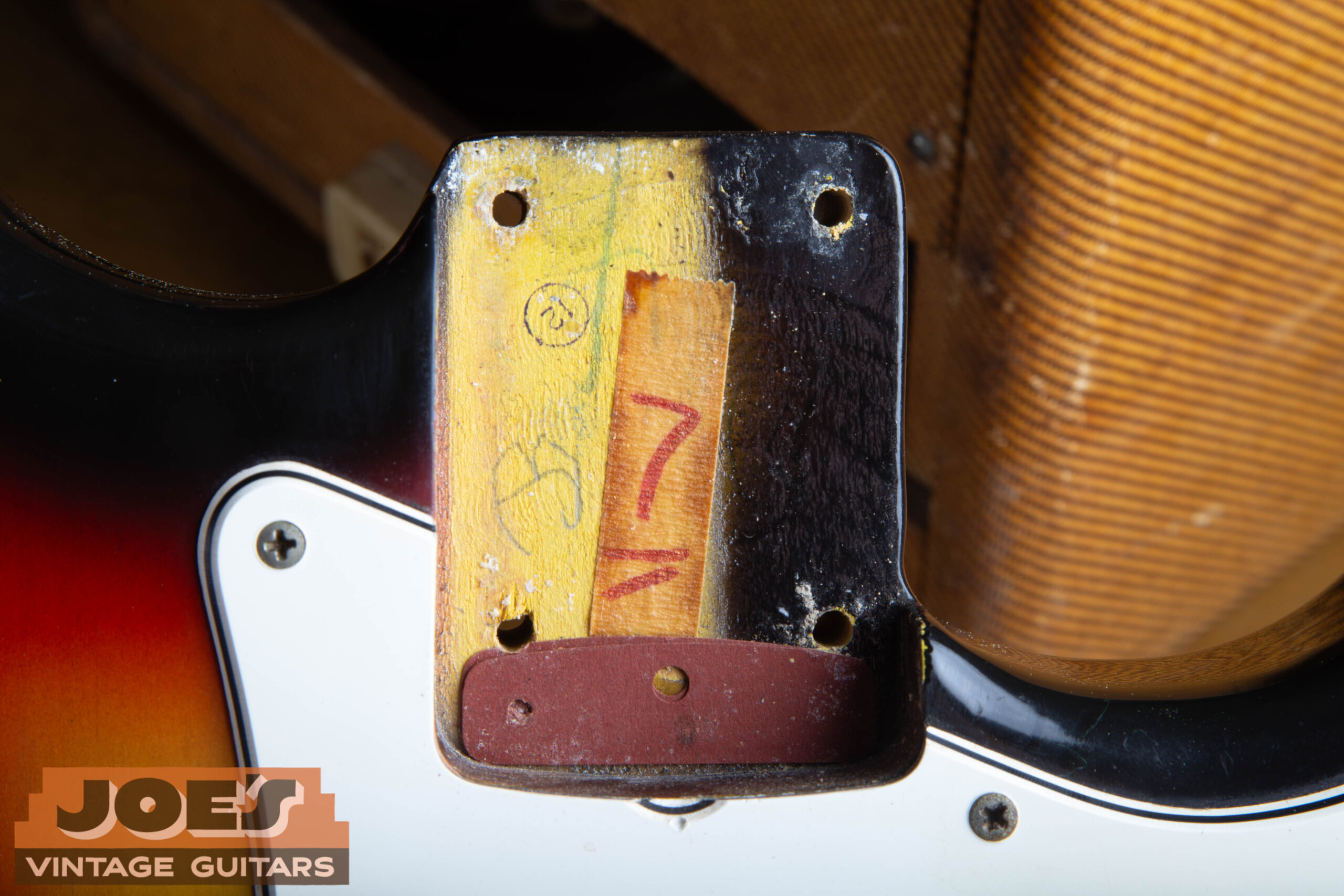 1966 Stratocaster neck pocket showing the paint stick shadow and the original dark red vulcanized fiber shim under the neck heel
